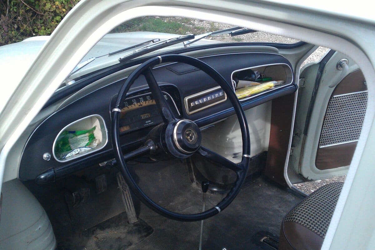 Tableau de bord d’origine d’une Renault Dauphine, volant fin et compteur gradué, un état de conservation qui pèse sur la cote